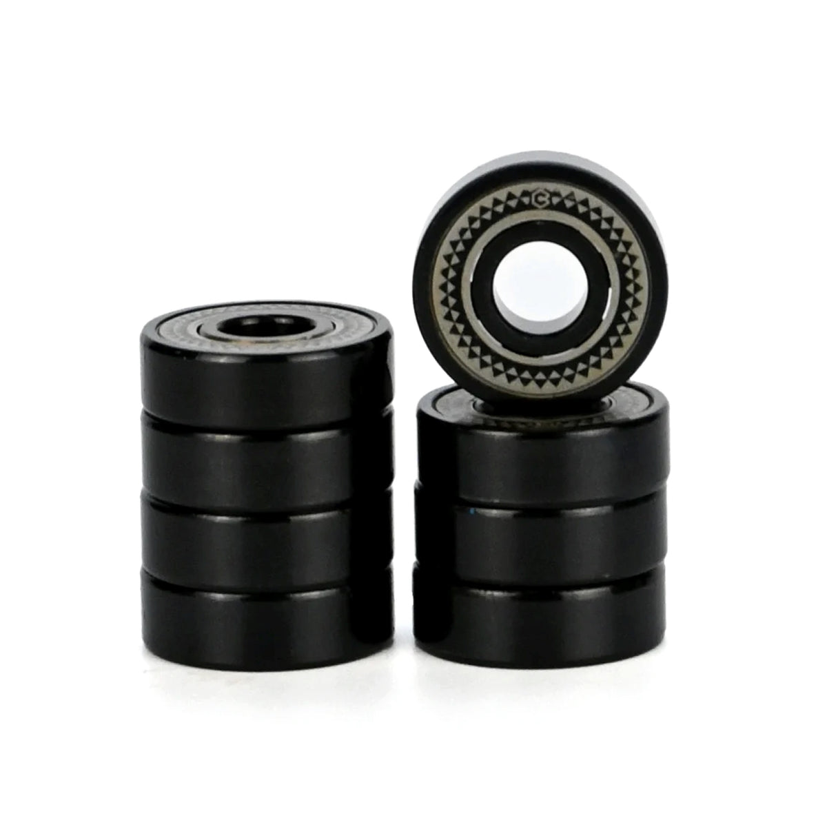 Four black metal bearings in two stacks with one bearing standing upright to show its inner race and outer ring details, set against a plain white background.