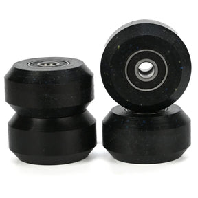 4 black aggressive inline skating anti rocker wheels with black bearings inside them. there are 2 stacked in the left of the image and 2 stacked on the right. the background is white.