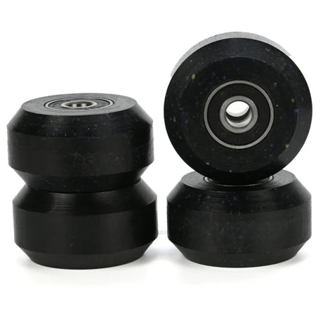 4 black aggressive inline skating anti rocker wheels with black bearings inside them. there are 2 stacked in the left of the image and 2 stacked on the right. the background is white.