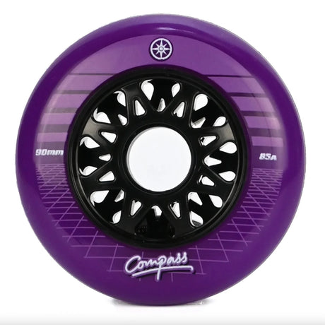 A single purple inline skate wheel with a black multi-spoke hub, featuring the brand name Compass and a "compass star" logo, on a white background.