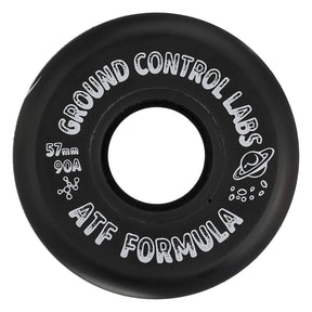 A close up shot of a black skate wheel with white text that reads "GROUND CONTROL LABS 57mm 90A ATF FORMULA" and a white graphic of a planet with a ring. The wheel is featured on a white background.