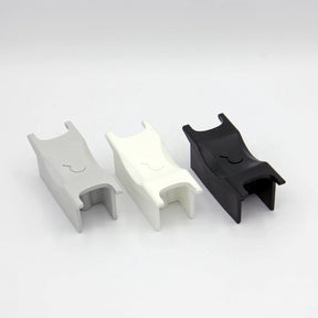 3 aggressive inline skate frame 'H-block' parts in grey, white and black lined up next to each other on a white background.