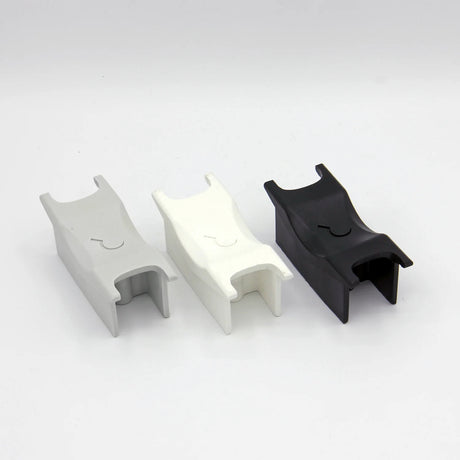 3 aggressive inline skate frame 'H-block' parts in grey, white and black lined up next to each other on a white background.