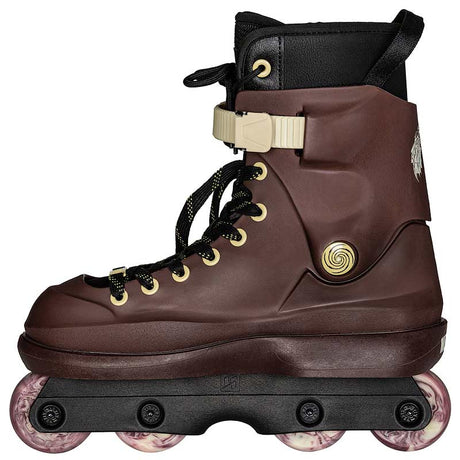 A dark brown inline skate boot with black laces, gold-tone hardware accents, a black ankle strap, and translucent pinkish-purple wheels on a black chassis, shown against a plain white background.
