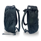 Two black canvas backpacks viewed from the side with strap and buckles as well as mesh pockets attached. The two backpacks are featured against a plain white background.