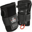 Two black wrist guard pads next to each other standing upright against a white background. The pads feature velcro straps with a brand logo on it, thumb holes, and a rigid plastic piece protruding out where your palm would be.  There is also a small orange loop of cord attached to the bottom. 