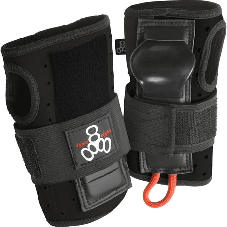 Two black wrist guard pads next to each other standing upright against a white background. The pads feature velcro straps with a brand logo on it, thumb holes, and a rigid plastic piece protruding out where your palm would be.  There is also a small orange loop of cord attached to the bottom. 