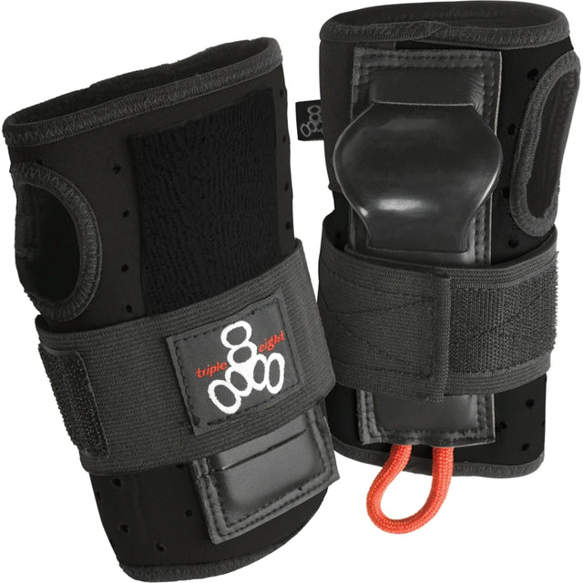 Two black wrist guard pads next to each other standing upright against a white background. The pads feature velcro straps with a brand logo on it, thumb holes, and a rigid plastic piece protruding out where your palm would be.  There is also a small orange loop of cord attached to the bottom. 